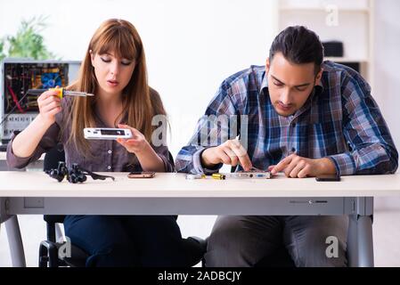 Two technicians working at computer warranty center Stock Photo