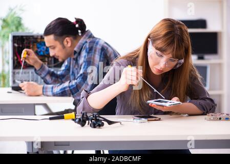 Two technicians working at computer warranty center Stock Photo