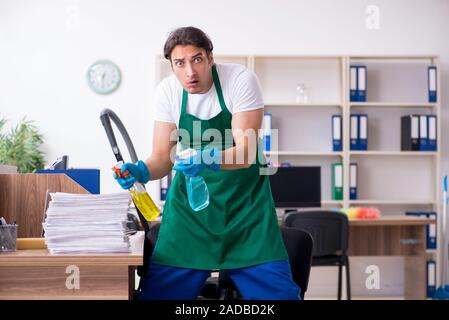 Young handsome contractor cleaning the office Stock Photo