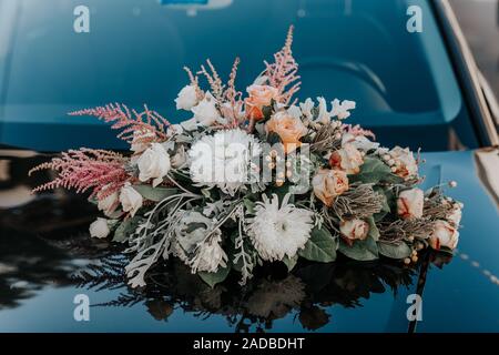 Fresh flowers on the car. Beautiful bouquet of flowers.Wedding bouquet in the background of the machine. Stock Photo