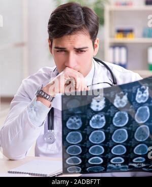 Young doctor looking at x-ray images in clinic Stock Photo