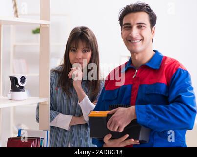 Client getting securty camera installed at home by contractor Stock Photo