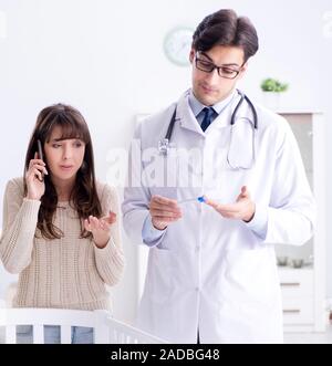 The doctor explaining to young mother Stock Photo