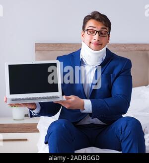 Businessman with neck injury working from home Stock Photo