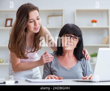 Daughter explaining to mom how to use computer Stock Photo