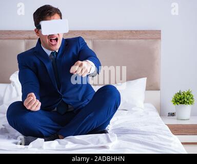 Businessman wearing a virtual reality headset in the bedroom Stock Photo