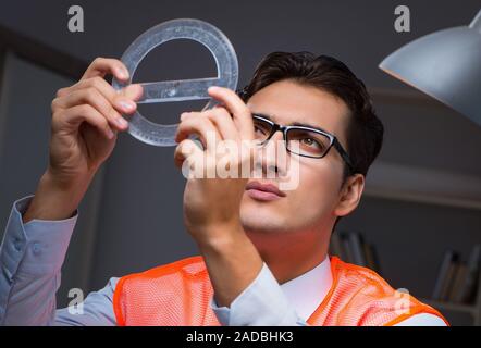 Construction architect working on drawings late at night Stock Photo