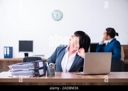 Two employees doing sport exercises in the office Stock Photo