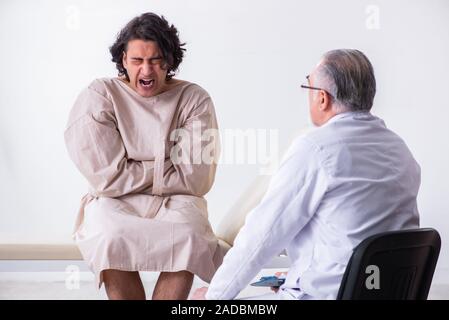 Aged male doctor psychiatrist examining young patient Stock Photo