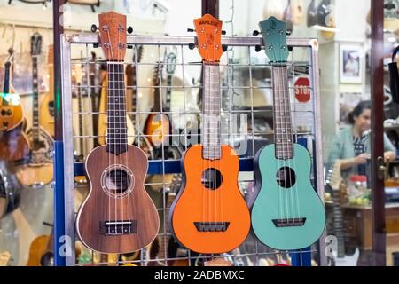 GREECE, AEGINA ISLAND - NOVEMBER 30, 2019: Three multi-colored small guitars ukulele on a local market Stock Photo