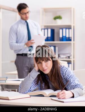 Male lecturer giving lecture to female student Stock Photo