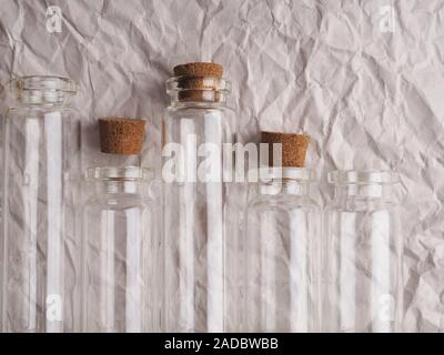 small glass bottles on crumpled paper, banner, medicine and research. Small glass bottles with cork lid. Stock Photo