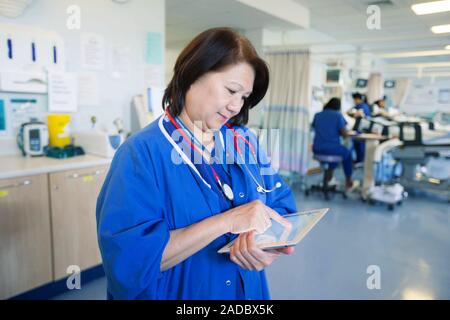 Doctor using tablet computer. Doctor using a tablet computer while at work in a hospital. Stock Photo