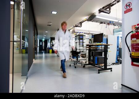Proteomics and mass spectrometry laboratory. Researchers walking in a laboratory that uses mass spectrometers to analyse proteins. This is part of a p Stock Photo
