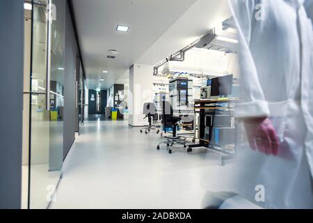 Proteomics and mass spectrometry laboratory. Researchers walking in a laboratory that uses mass spectrometers to analyse proteins. This is part of a p Stock Photo