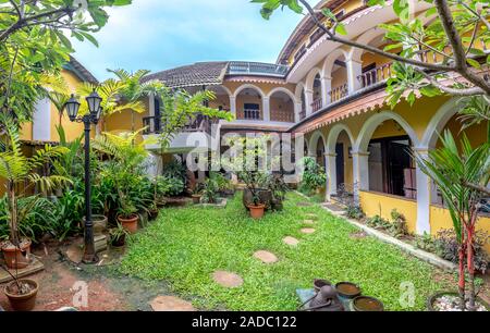 Enclosed green courtyard for relaxing in hotel with trees Stock Photo