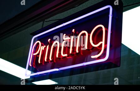 St Louis, USA. May 12, 2019. Printing Neon Sign. Electric red letters on glass board advertise the store. Close up view with details. Stock Photo