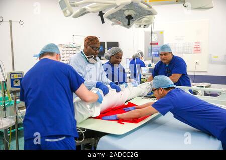Intestinal surgery. Surgical team preparing to operate to remove part of a patient's intestines. The team includes a specialist in colorectal cancer s Stock Photo