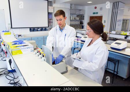 Chemistry students in an undergraduate teaching laboratory loading eppendorf sample tubes into a centrifuge Stock Photo