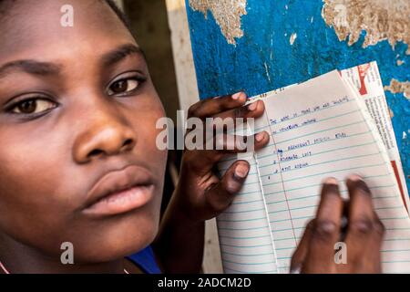 Schoolgirl writing notes at school. Photographed in Lacor, Gulu, Uganda. Stock Photo