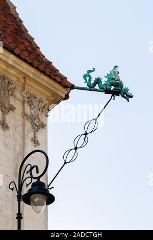 A metal Gargoyle representing dragon with a spout, designed to carry water from the roof in Old Town Market Square, Warsaw, Poland, in spring Stock Photo