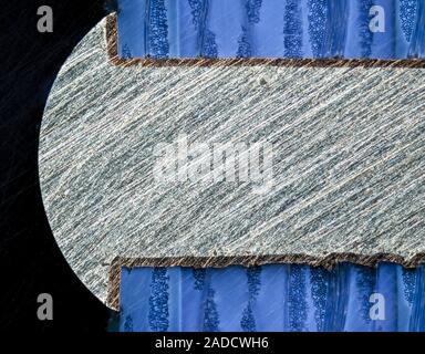 Light micrograph of a section through a computer multilayer printed circuit board (PCB) with a via filled with solder. A via is an electrical connecti Stock Photo
