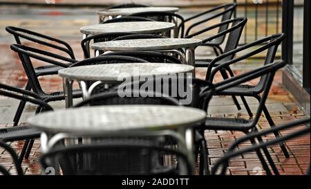 Metal tables and chairs outside restaurant on a rainy day in Fleetwood Stock Photo