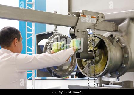 A craftsman is repairing industrial tape at a factory. Troubleshoot manufacturing issues. Man-master repairs the production line. Stock Photo