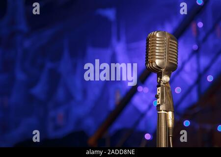 Retro microphone against dim blue light restaurant background Stock Photo