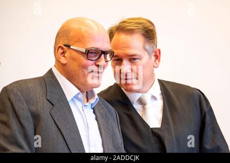 Detmold, Germany. 04th Dec, 2019. The accused Rolf Herbrechtsmeier (l) and his defender Carsten Ernst talk to each other. The public prosecutor's office in Detmold accuses the accused of 'driving licence king' Herbrechtsmeier of 505 cases of fraud which allegedly led to a total loss of almost 650,000 euros. Credit: David Inderlied/dpa/Alamy Live News Stock Photo