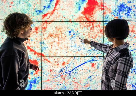 IBM PAIRS Geoscope research. Researchers with a visualization from the IBM PAIRS Geoscope website (Physical Analytics Integrated Data Repository and S Stock Photo