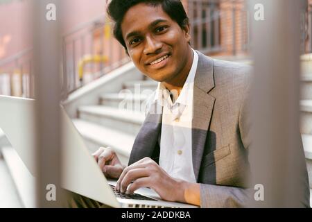 Young handsome Indian man is sitting on the steps Stock Photo