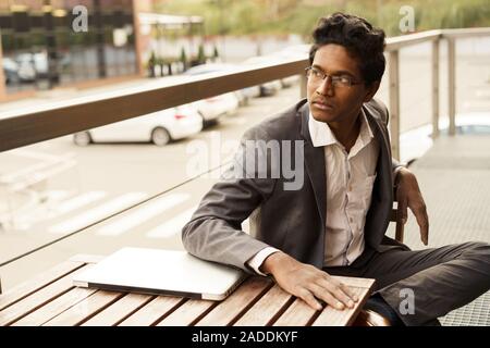 Young handsome man is sitting at the table Stock Photo
