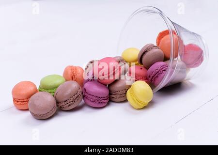 Colorful mini macarons a scattering of packaging on white background Stock Photo