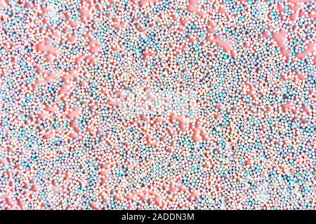 Small foam balls on pink pastel background and the inscription Xmas Stock Photo