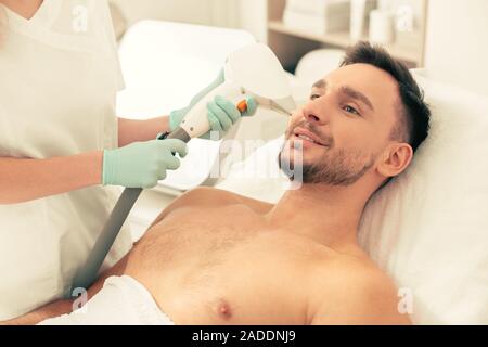 Close up of positive man in the clinic having hair removed Stock Photo