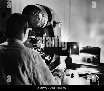 Researcher using a microscope, 20th century. This microscope is being used in the study of refractory materials as part of metallurgical research rela Stock Photo