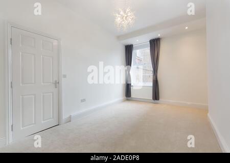 An empty stylish modern room in an apartment with plain white walls Stock Photo