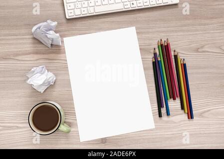 Blank paper, colored pencils and crumpled paper balls on desk