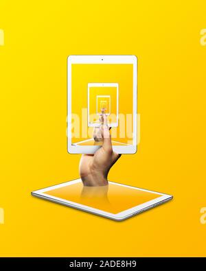 Person holding digital tablet with repeating image against yellow background. Stock Photo