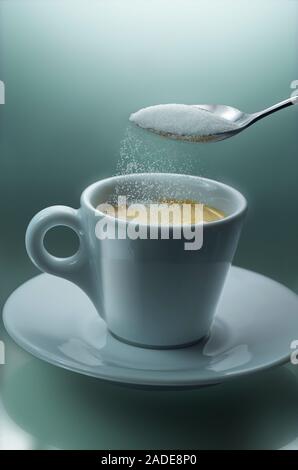 Pouring sugar from teaspoon into cup of coffee, plain background. Stock Photo