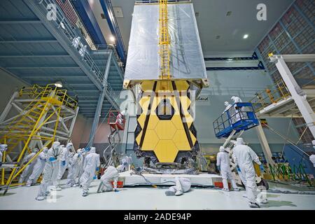 James Webb Space Telescope (JWST) assembly. Engineers in clean-room clothing watching a protective tent being placed over the JWST. This protects the Stock Photo