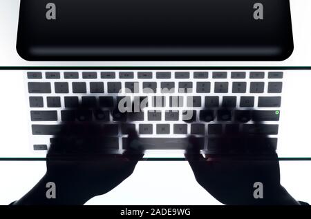 Person using laptop and typing on keyboard, high angle view. Stock Photo