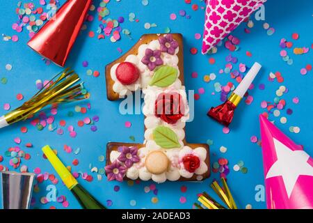 Number one cake decorated with flowers, macarons on blue background Stock Photo