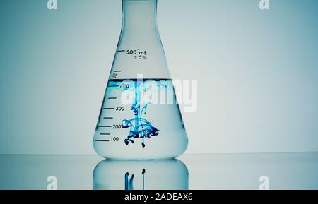 Blue liquid diffusing in flask. Stock Photo