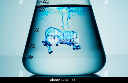 Blue liquid diffusing in flask. Stock Photo