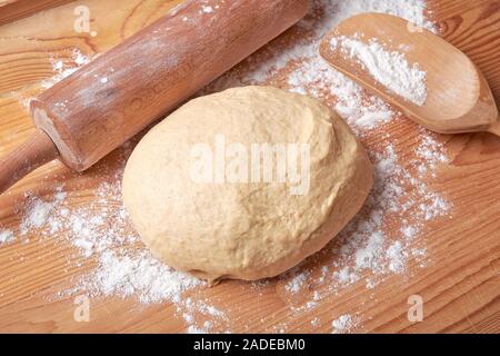 Kneaded dough on a rolling plate with spilled wheat flour. Stock Photo