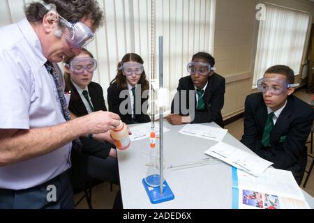 Secondary School teacher demonstrating a titration chemistry experiment to a group of students. Stock Photo
