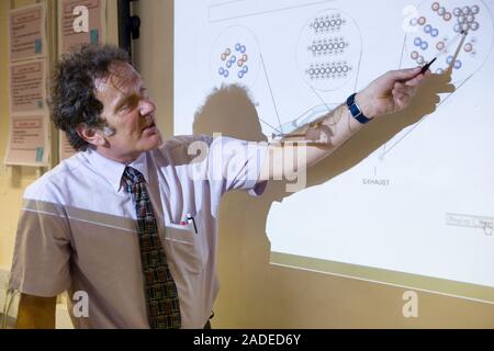 Secondary School teacher using the whiteboard to explain the background to car combustion and air quality, part of a core module of a science course. Stock Photo