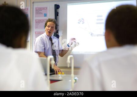 Secondary School teacher using the whiteboard to explain the background to car combustion and air quality, part of a core module of a science course. Stock Photo